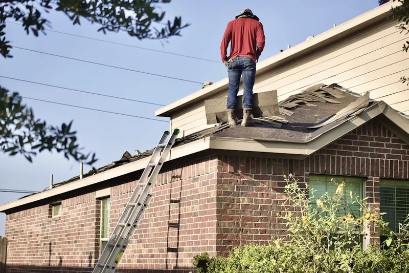 Professional roofer working on a residential roof in Forest Village